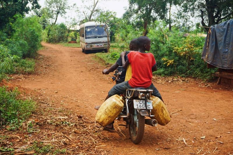 People on motorcycle with water canisters